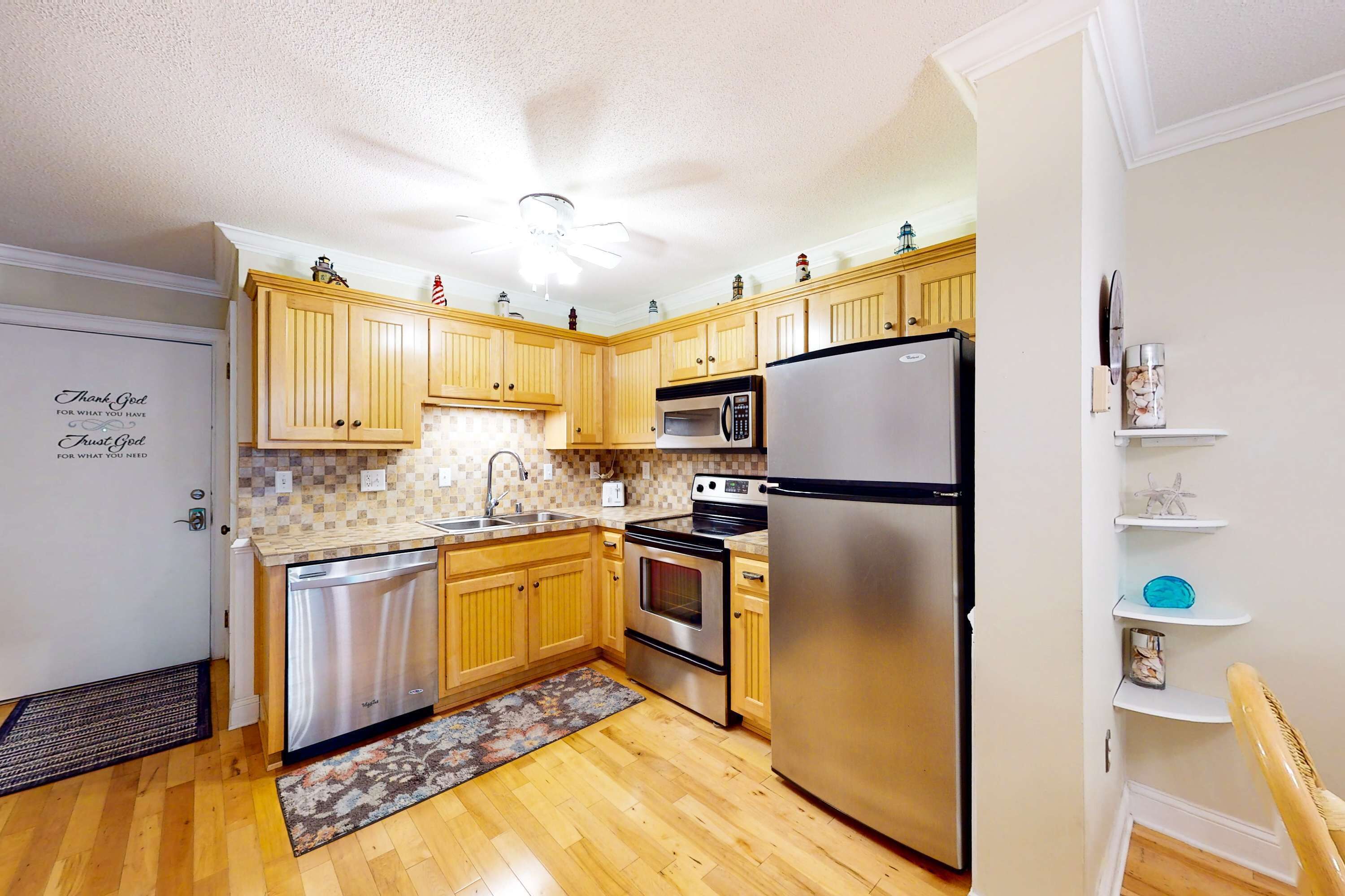 A kitchen with wooden cabinets, stainless steel appliances, a dishwasher, and a refrigerator.