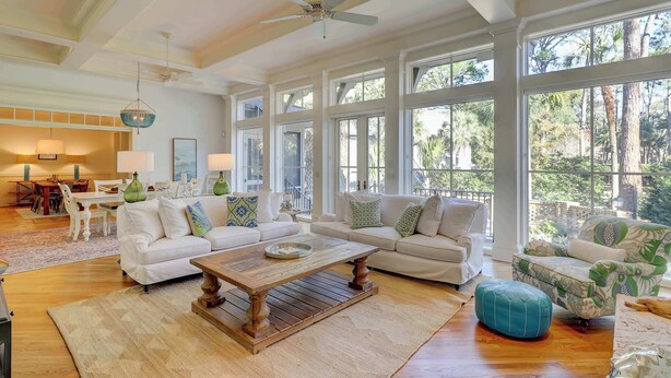 A spacious living room with a large wooden coffee table, two white sofas, and a patterned armchair. - Luxurious home with private pool, central AC, & high-speed WiFi - walk to beach (Hilton Head)