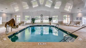 An indoor swimming pool with clear water, surrounded by lounge chairs and potted plants. - Private condo with sound views, effortless beach access, & resort amenities (Hilton Head)