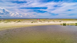 A flat landscape with a body of water, a red structure, and a clear sky. - Private condo with sound views, effortless beach access, & resort amenities (Hilton Head)