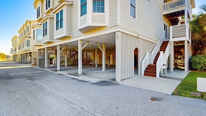 A multi-story hotel with a covered entrance, outdoor stairs, and a parking lot. - Sea Sea Rider (Edisto Beach)