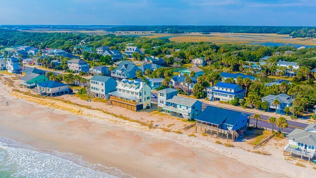 Un quartier résidentiel situé sur la côte, avec des maisons, une plage et une vue sur l’océan.
