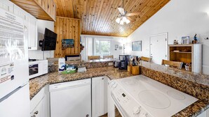 A kitchen with granite countertops, white appliances, wooden ceiling, and a ceiling fan. - 3rd-floor, dog-friendly condo with loft, balcony, free WiFi and golf course view (Edisto Beach)