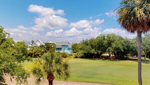 A golf course with a house in the background. - 3rd-floor, dog-friendly condo with loft, balcony, free WiFi and golf course view (Edisto Beach)