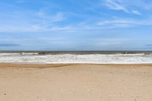 Ein Strand mit sandigem Ufer und Wellen.