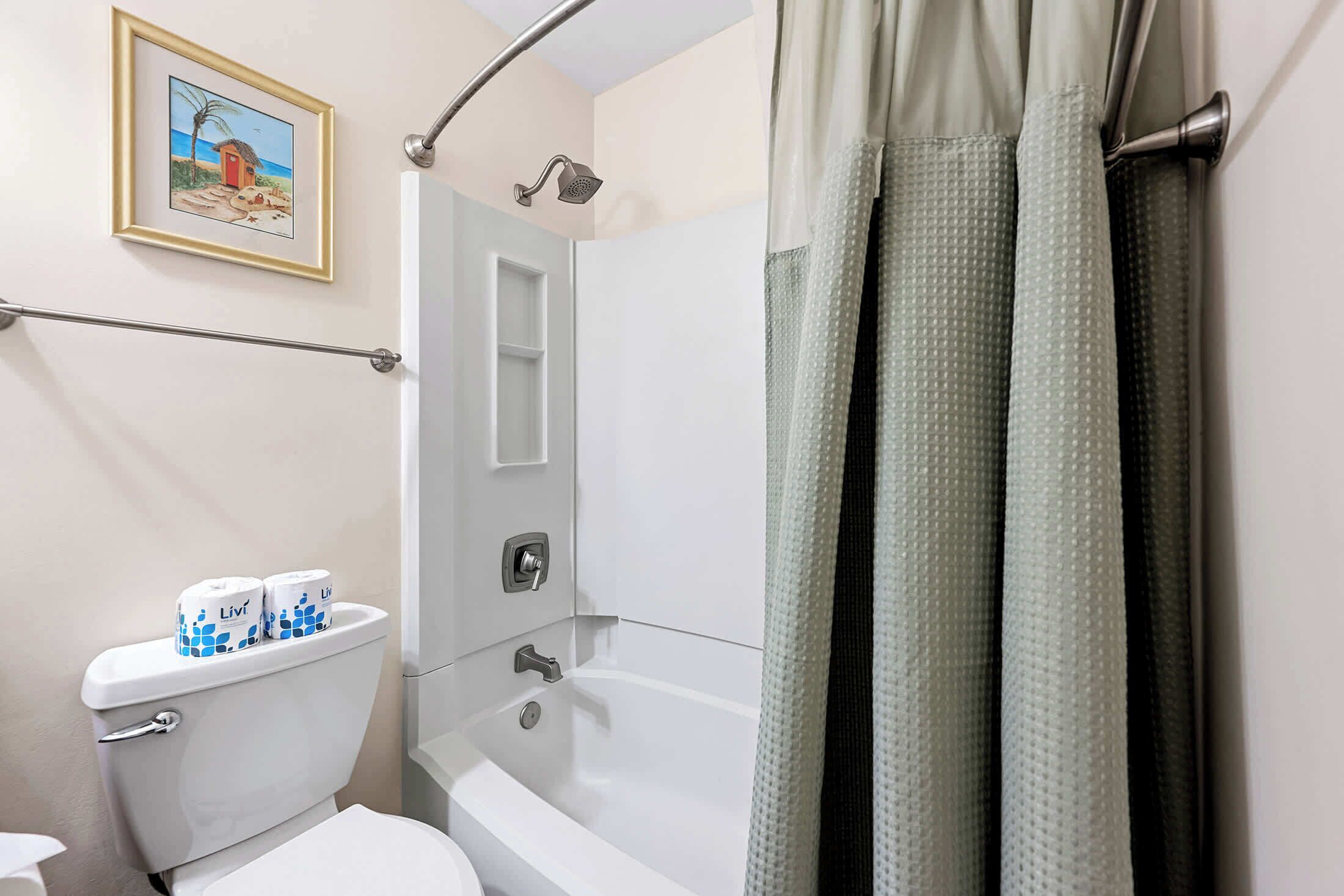 Une salle de bain équipée de toilettes, d’une douche et d’une baignoire.