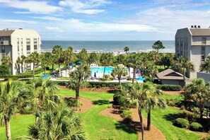 A resort with a pool, palm trees, and a view of the ocean. - Updated beach gem with ocean views, pool, hot tub, & tennis - snowbird-friendly (Hilton Head)
