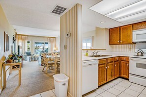 A kitchen with wooden cabinets, a dishwasher, and a microwave. - Beachfront condo with large furnished balcony, pool & beautiful views (Hilton Head)