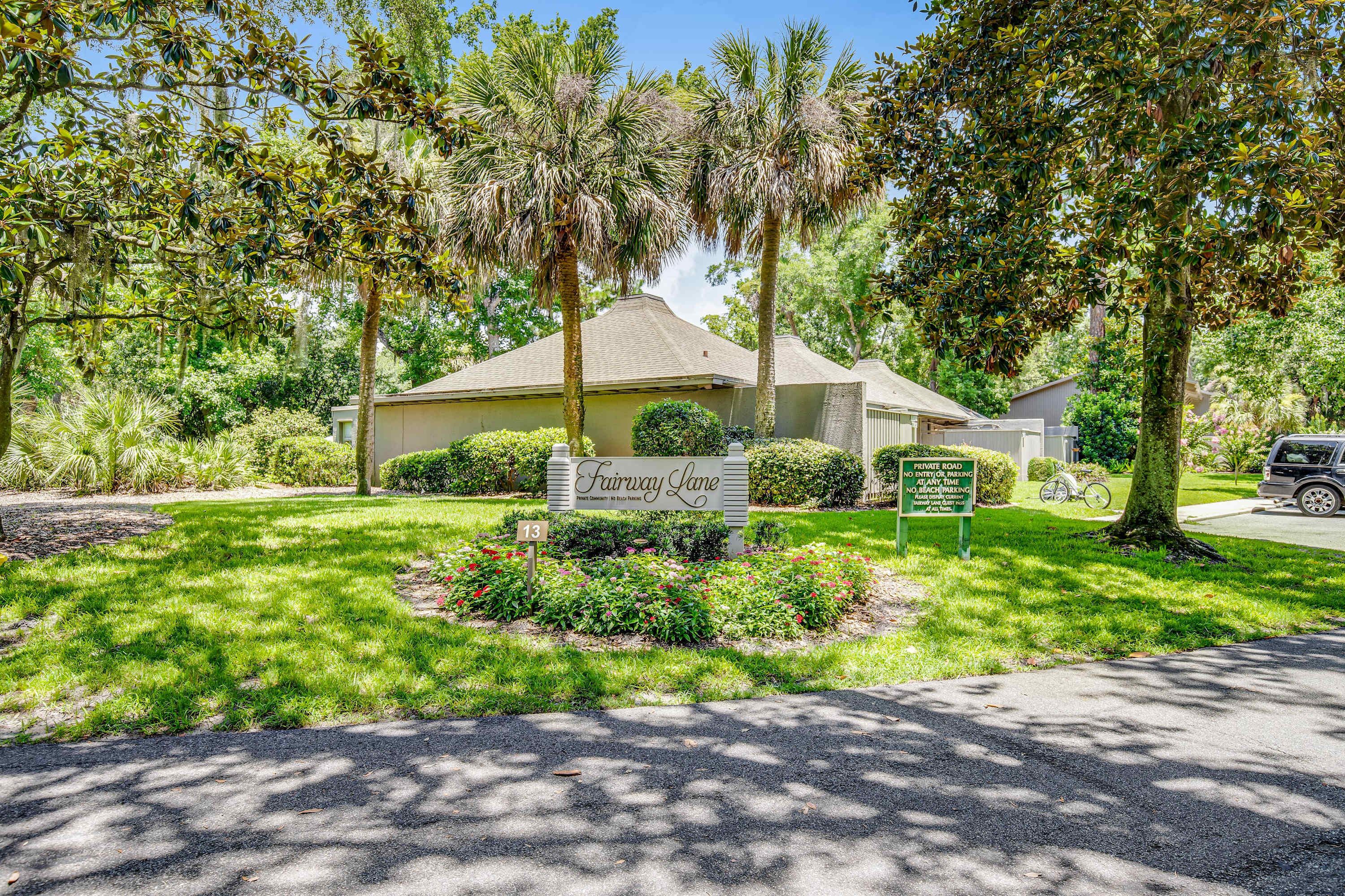 A residential property named 'Fairway Lane' with a well-maintained lawn, mature trees, and a private road sign.