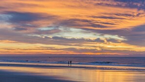A beach with a sunset and ocean waves. - Beautifully remodeled villa with WiFi, inviting porch & balconies walk to beach (Hilton Head)