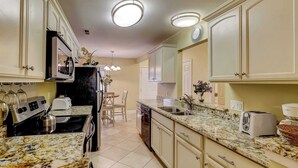 A kitchen with a stove, microwave, oven, and a dishwasher. There are cabinets, a countertop, and a sink. - Beautifully remodeled villa with WiFi, inviting porch & balconies walk to beach (Hilton Head)