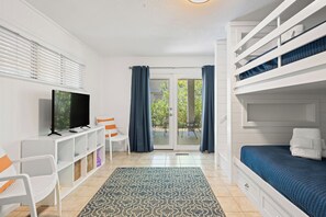 A compact room with a bed, a TV, a desk, and a chair. - North Forest Beach home with large deck, three houses from the beach (Hilton Head)