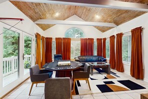 A room with a round table, chairs, a sofa, and a foosball table. - Bright and spacious home in Sea Pines,  perfect for families! (Hilton Head)