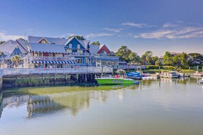 A waterfront building with a dock, boats, and a calm lake. - Bright and spacious home in Sea Pines,  perfect for families! (Hilton Head)