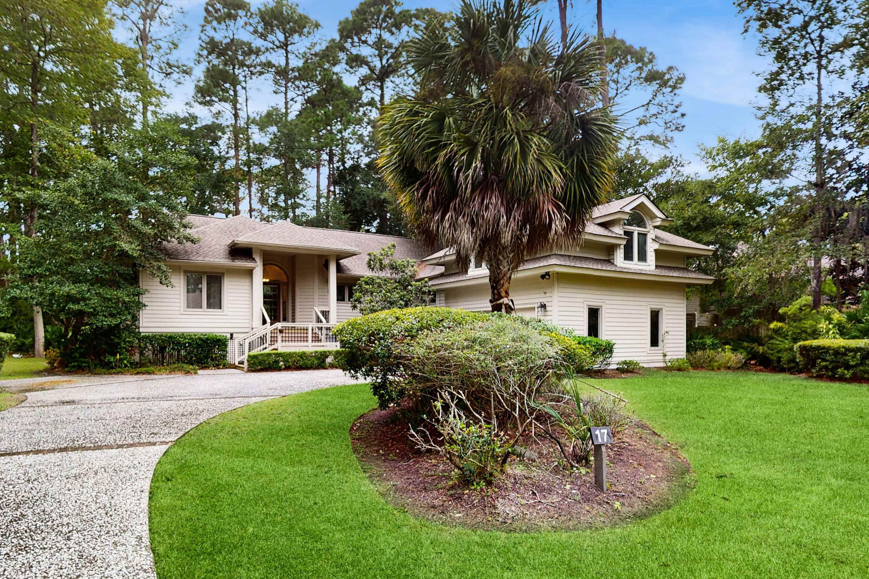 A single-story house with a front porch, a driveway, and a well-maintained lawn.