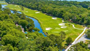 Un parcours de golf agrémenté d’obstacles d’eau, de bunkers de sable et offrant une vue dégagée sur l’océan.