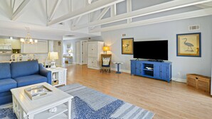 Un salon spacieux comprenant un canapé, une table basse et un meuble pour appareils multimédias.