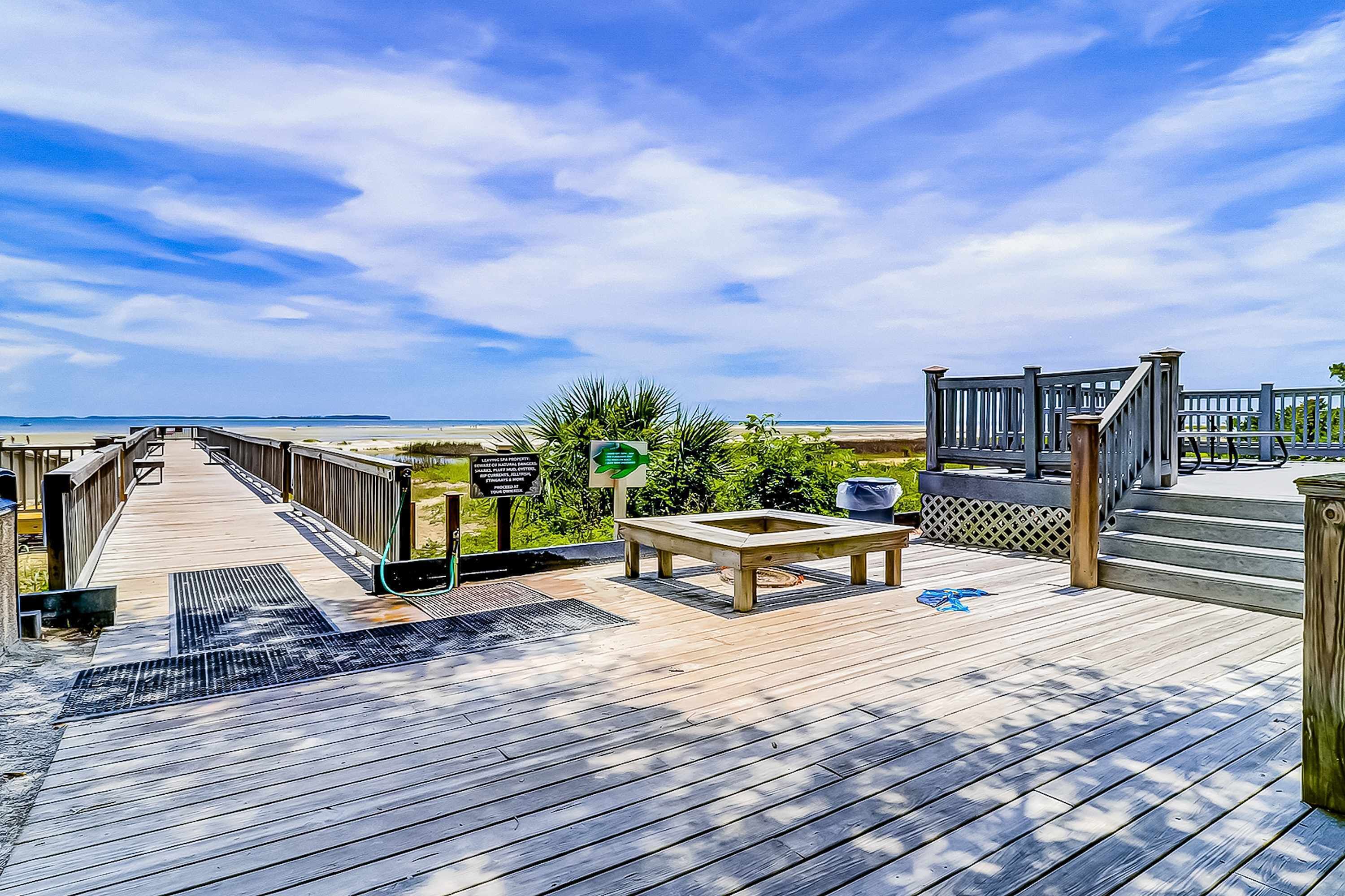 A wooden deck with a bench, a trash bin, and a sign indicating a direction.