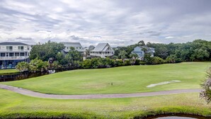 A golf course with a water body, surrounded by houses and greenery. - Top-floor villa with fairway views - central AC, private W/D, WiFi - Dogs OK (Edisto Beach)
