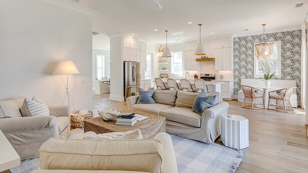 Un salon moderne avec un canapé, une table basse et un coin repas avec des chaises.