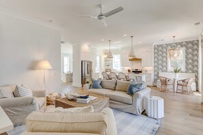 Un salon moderne avec un canapé, une table basse et un coin repas avec des chaises.