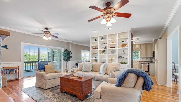 A spacious living room with a large sofa set, a coffee table, and a ceiling fan. - Spacious home near beach with access to resort amenities & free state park entry (Edisto Beach)
