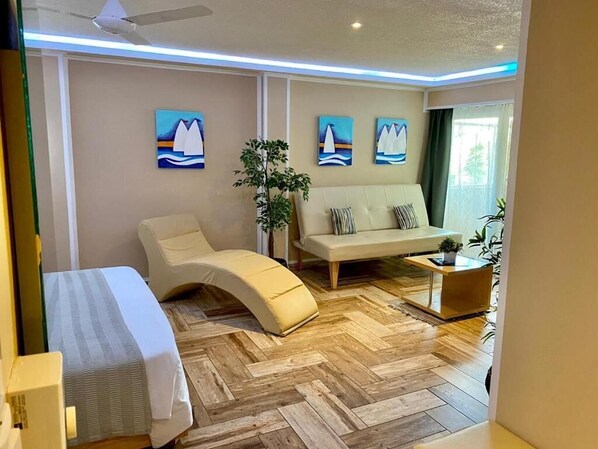 Habitación junior, balcón, vista al patio | Área de sala de estar