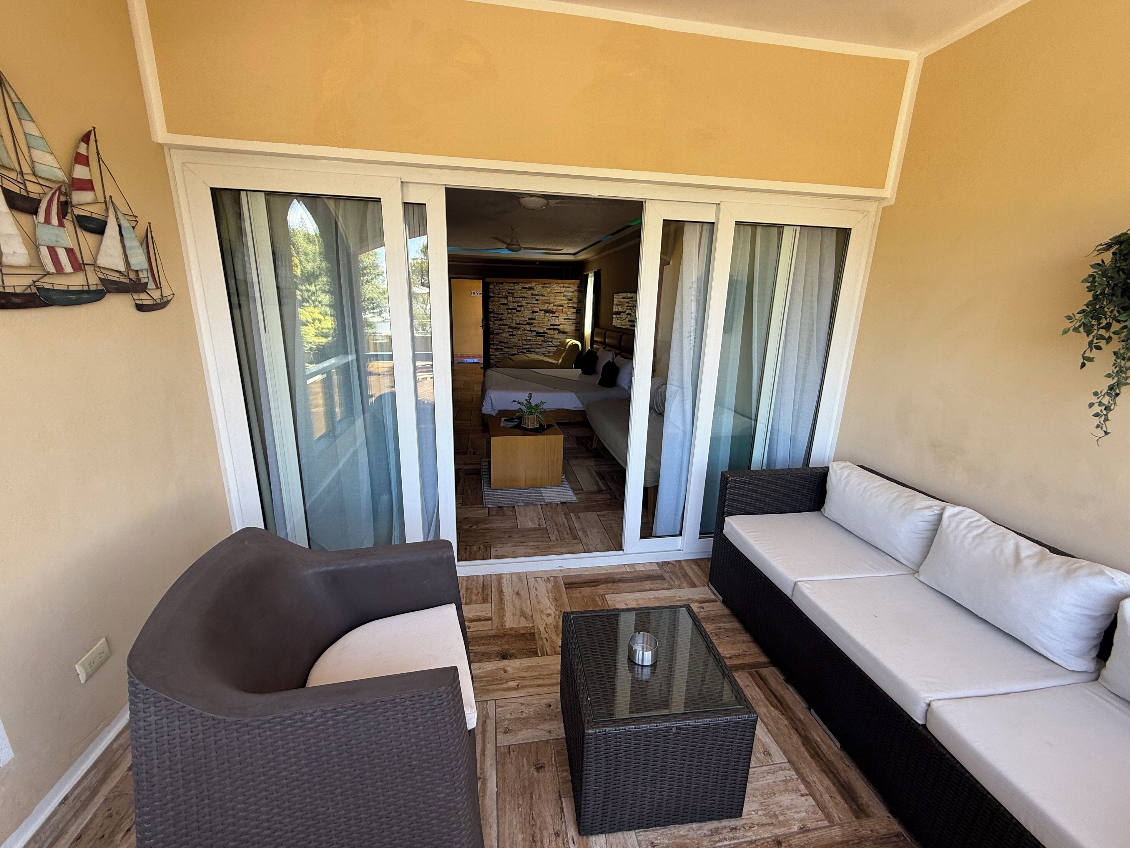 A balcony with a sofa, a coffee table, and a dining area with a table and chairs.