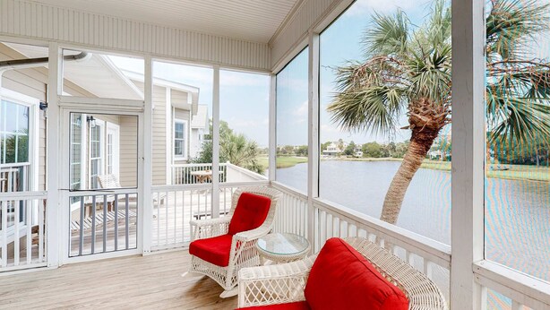 A covered outdoor area with wicker furniture and a view of a lake. - Charming Home w/ Lagoon View, WiFi, Laundry, Central AC - Walk to the Beach (Edisto Beach)