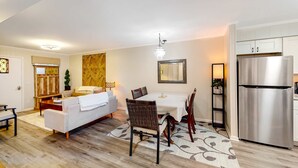 A modern living room with a dining area, a kitchen with a stainless steel refrigerator, and a chandelier. - The Hedges D1 Condo in Hilton Head with pool & tennis, walk to the beach (Hilton Head)