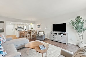 Een moderne woonkamer met een bank, salontafel en een televisie op een dressoir.
