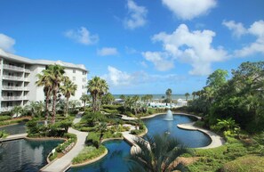 A resort with multiple swimming pools, palm trees, and a building with balconies. - Waterfront condo with amazing views, on-site pool, hot tub, & gym (Hilton Head)