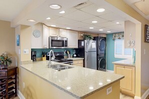 A kitchen with granite countertops, stainless steel appliances, and a central island. - Relaxing villa with pool, hot tub & tennis - partial ocean view (Hilton Head)