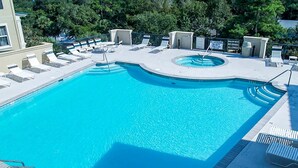 A rectangular swimming pool with a curved section, surrounded by lounge chairs and a small poolside area with a trash bin. - Well-appointed villa with rooftop pool & beach access - 1 block to Coligny Plaza (Hilton Head)