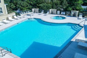 A rectangular swimming pool with a curved section, surrounded by lounge chairs and a small poolside area with a trash bin. - Well-appointed villa with rooftop pool & beach access - 1 block to Coligny Plaza (Hilton Head)