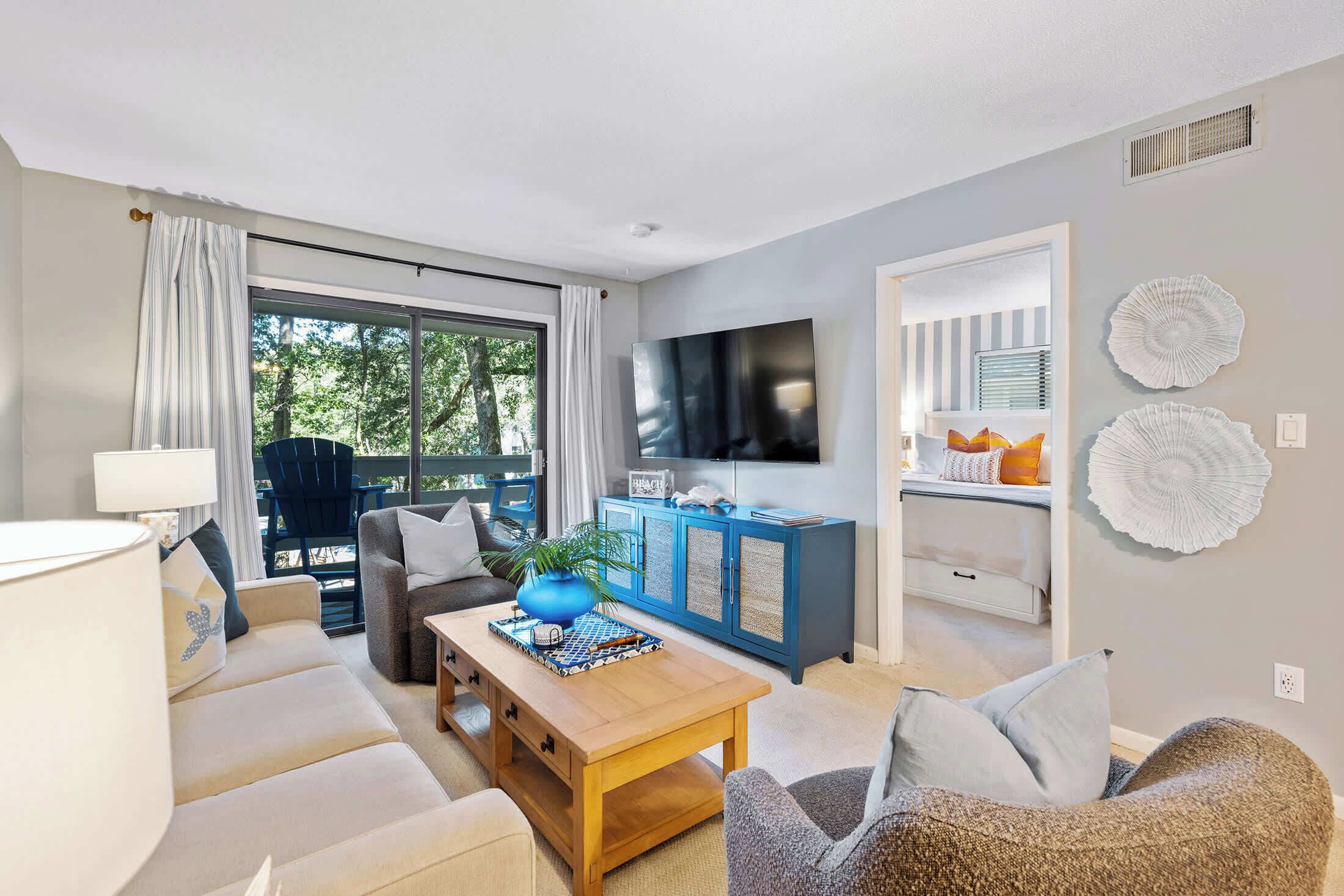 A modern living room with a sofa, coffee table, and a TV mounted on the wall.