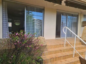 A building with a staircase leading to a door, a small garden with pink flowers, and a clear view of the sky. - Oasis in Montpellier Private Garden Pool Beaches (Montpellier)