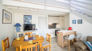 Un espacio moderno de estar con comedor, cocina y una escalera.