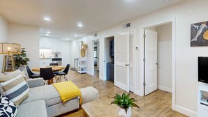 Un salon moderne avec un canapé, une table basse et un coin repas.