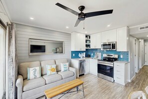 A modern kitchen with white cabinets, a microwave, and a stove. - Newly Renovated Coastal Condo with Ocean-View Balcony, Shared Pool & Easy Beach Access (Hilton Head)