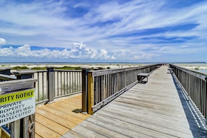 A wooden boardwalk leading to a beach with a 'PRIVATE PROPERTY PASSERS WILL BE PROSECUTED' sign. - Coastal condo with indoor and outdoor pool, tennis and pickleball courts (Hilton Head)