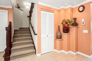 A staircase with a wooden handrail, beige carpeted steps, and a white door at the top. - Spacious Mauna Lani Condo With Beach Club Access - Vrkcv (Kamuela)