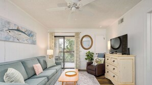 A living room with a sofa, a coffee table, a television, and a cabinet.
