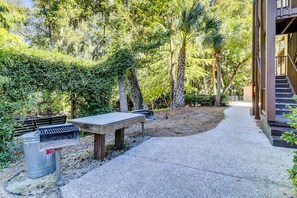 A concrete pathway leading to a building with a wooden deck and a metal grill. - Condo 1 block from Coligny Plaza with on site pool, balcony, Washer, Dryer (Hilton Head)