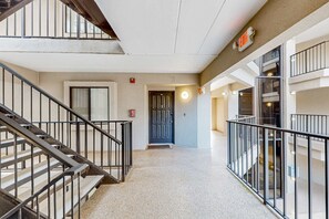 A multi-level interior with a staircase, a door with a circular light, and a fire alarm. - Close to beach with pool, tennis, pool  & private balcony (Hilton Head)