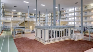 A multi-level hotel with balconies, a central courtyard, and a children's play area. - Beach condo with balcony, pools, & hot tub- near golf & beach (Hilton Head)
