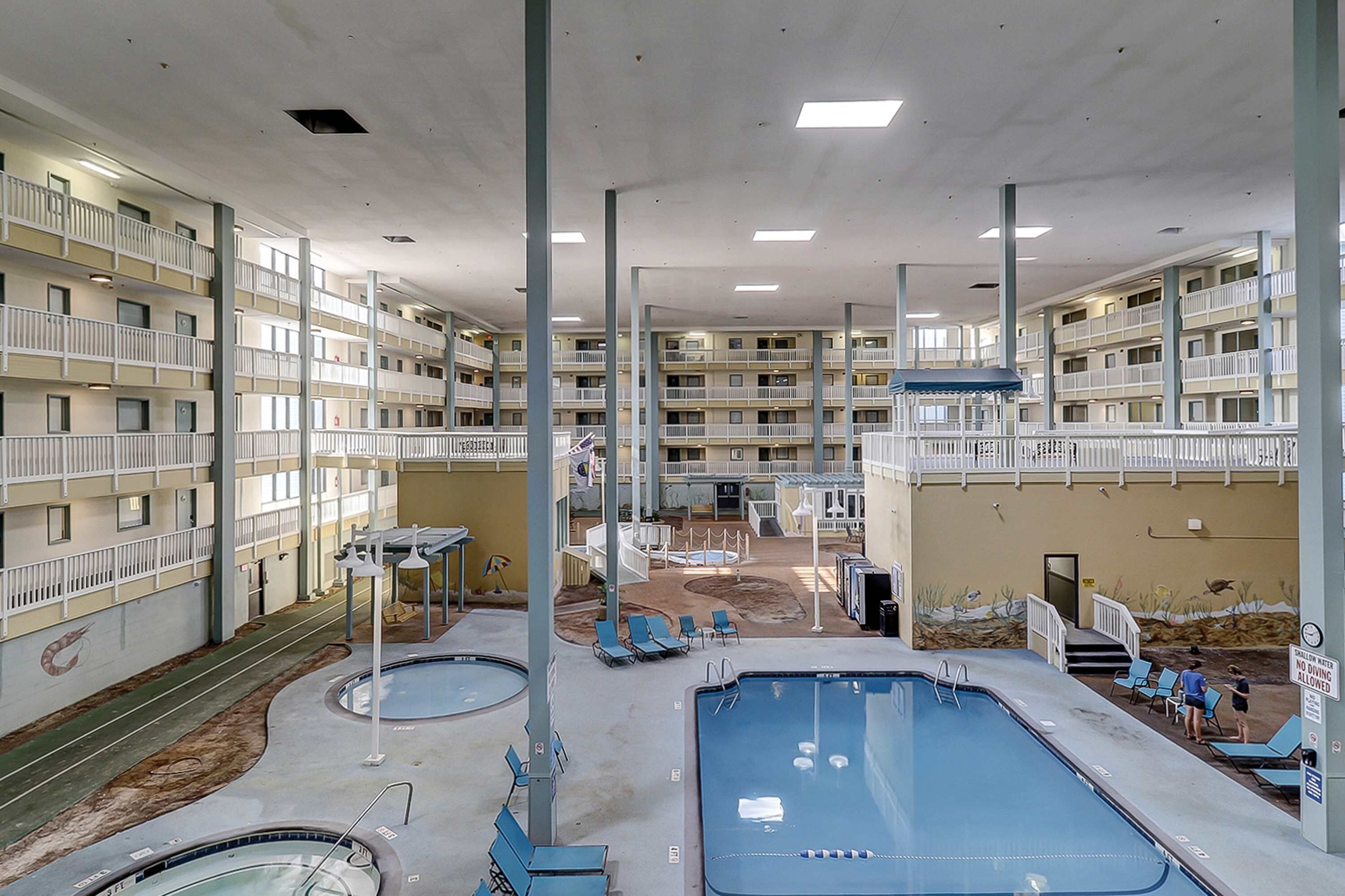 Um hotel com vários níveis, varandas, piscina e solário.