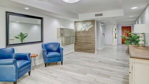 Un hall d’hôtel moderne comprenant un comptoir d’accueil, un espace salon et un mur décoratif en bois.
