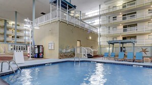 Ein Hallenbad mit einem mehrstöckigen Balkon, Liegestühlen und einer Pepsi-Getränkeautomaten.