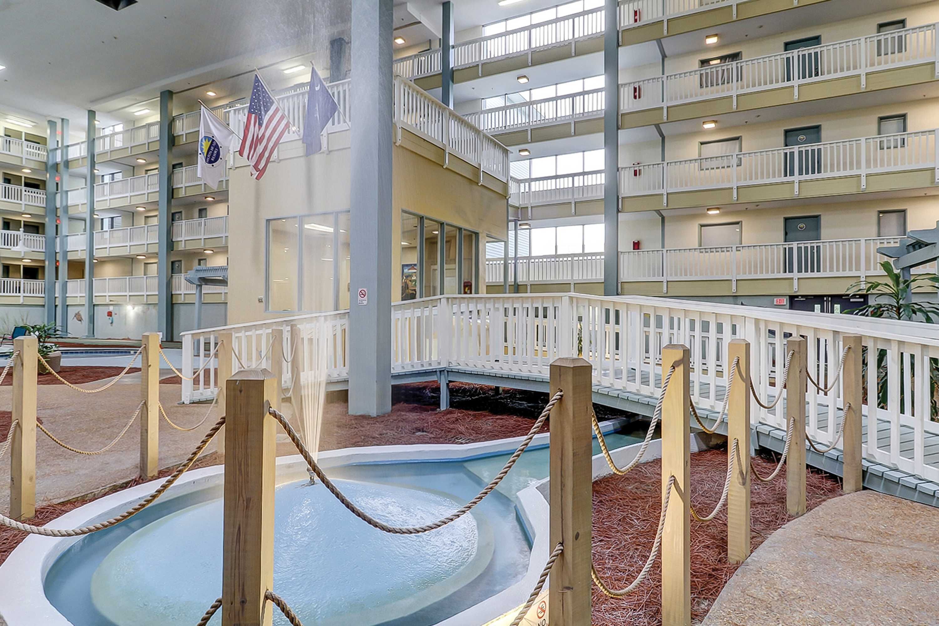 Uma piscina interior em vários níveis, com grades de madeira e uma barreira de corda.